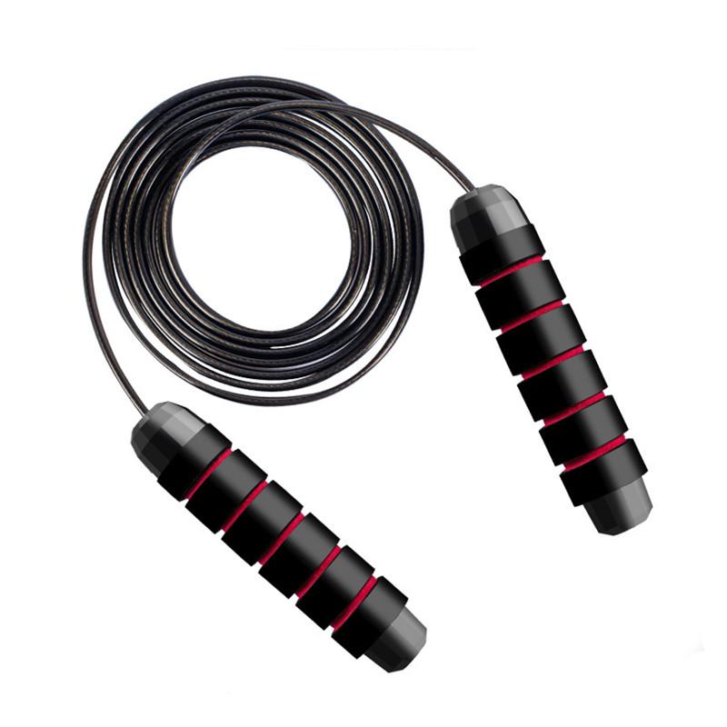 Justerbart hopprep med svarta handtag och rödsvart rep i hoprullat läge - Stabil Posture