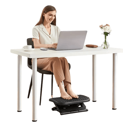 Kvinna använder fotstöd vid skrivbordet för bättre hållning